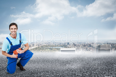 Composite image of happy carpenter holding drill machine