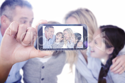 Composite image of hand holding smartphone showing