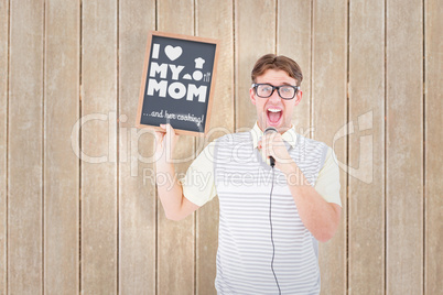 Composite image of geeky hipster holding blackboard and singing
