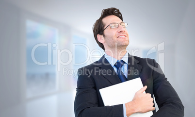 Composite image of handsome businessman holding his laptop