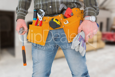 Composite image of manual worker holding gloves and hammer