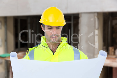 Composite image of architect analyzing blueprint