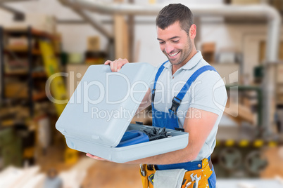 Composite image of happy repairman opening toolbox