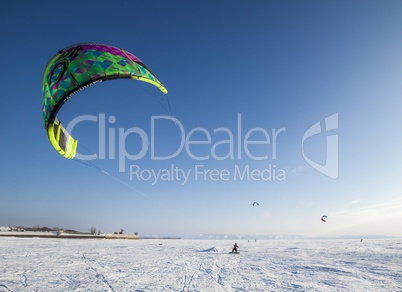 Kiteboarder with kite on the snow