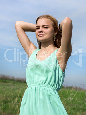 Young sensual smiling blonde posing in bright sunlight outdoors