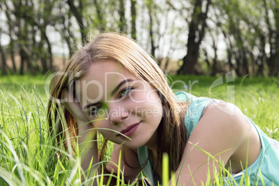 Young sensual smiling blonde lying on the grass in the sunlight