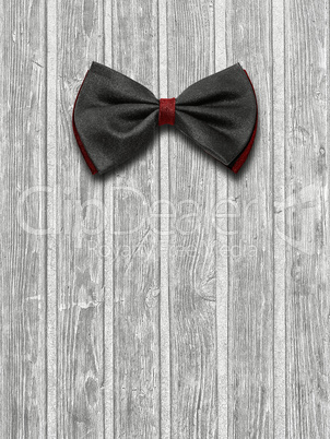 Black and red bow tie on a light wooden background