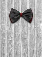 Black and red bow tie on a light wooden background