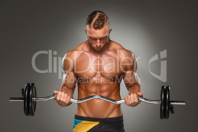 Portrait of super fit muscular young man working out in gym.