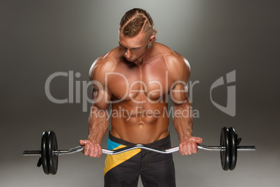 Portrait of super fit muscular young man working out in gym.