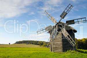 old wooden windmill in a field