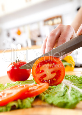 Woman's hands cutting tomato