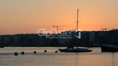 The timelaps of sunset and view on Sliema and sail yacht with Ukrainian flag, Sliema, Malta