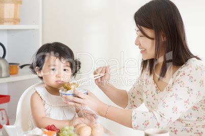 Asian mother feeding child