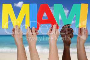 Hände halten das Wort Miami im Sommer am Strand und Meer