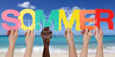 Hände halten das Wort Sommer am Strand und Meer in den Ferien