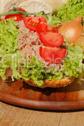 Fischbrötchen mit Thunfischfilet, Salat, Gewürzgurken, Zwiebeln