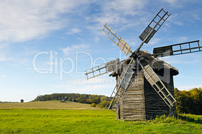 old wooden windmill in a field