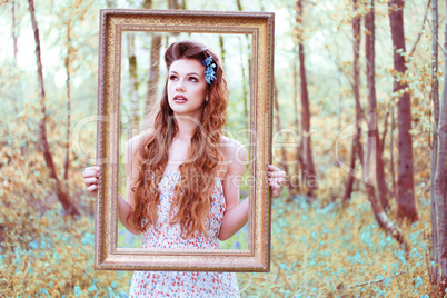 Ravishing woman looking through a portrait frame