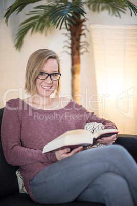 Junge Frau im Wohnzimmer liest ein Buch