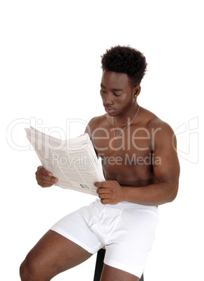 Black man in underwear reading.
