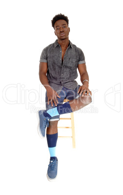 Black man sitting on chair.