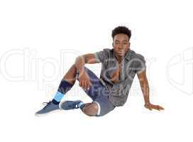 Black man sitting on floor.