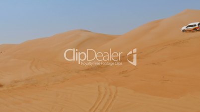 4WD car driving over dunes in oman desert