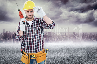 Composite image of confident handyman holding drill machine