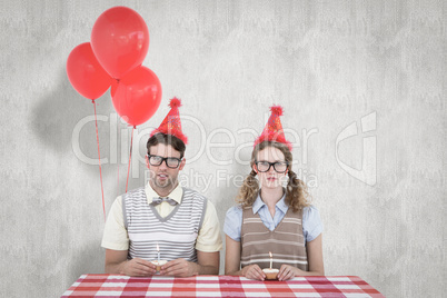 Composite image of geeky hipster couple celebrating his birthday