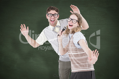 Composite image of geeky hipster couple singing into a microphon