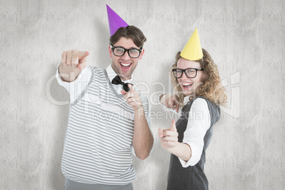 Composite image of happy geeky hispser couple dancing with party