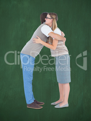 Composite image of geeky hipster couple hugging