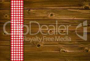 Holzhintergrund mit rot weisser Tischdecke