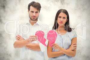 Composite image of upset couple holding two halves of broken hea