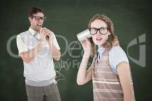 Composite image of geeky hipster couple speaking with tin can ph