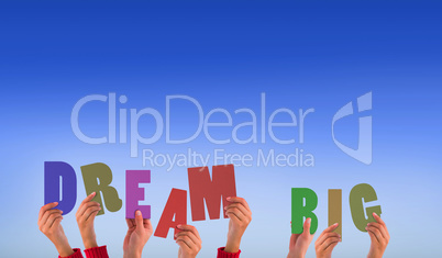 Composite image of hands holding up dream big