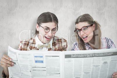 Composite image of geeky hipsters reading the newspaper