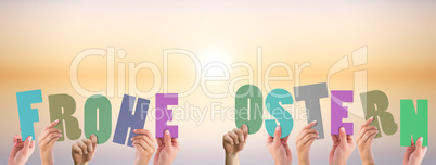 Composite image of hands holding up frohe ostern