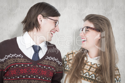 Composite image of happy geeky hipster couple looking at each ot