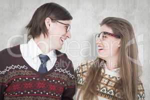 Composite image of happy geeky hipster couple looking at each ot