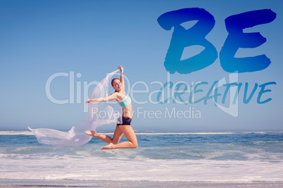 Composite image of fit woman jumping gracefully on the beach wit