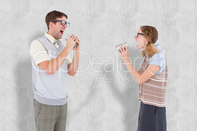 Composite image of geeky hipster couple speaking with tin can ph