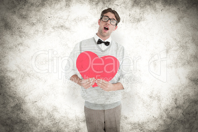 Composite image of geeky hipster holding heart card