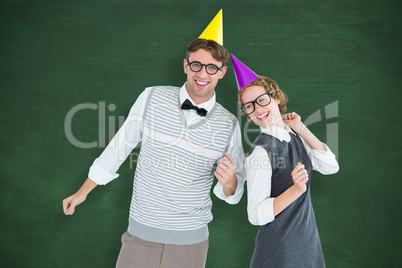 Composite image of geeky hipster couple wearing a party hat