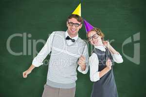 Composite image of geeky hipster couple wearing a party hat