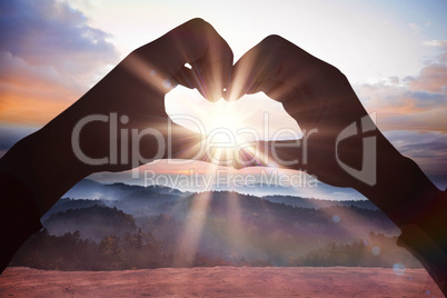 Composite image of woman making heart shape with hands