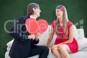 Composite image of cute geeky couple with red heart shape
