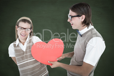 Composite image of geeky hipster offering red heart to his girlf