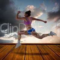 Composite image of fit brunette running and jumping